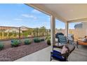 Covered patio with comfortable seating and a view of the manicured backyard at 11241 N Blakely St, Surprise, AZ 85388