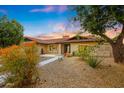Charming home showcasing desert landscaping, mature trees, and a tiled walkway leading to the entrance at 12448 N 76Th St, Scottsdale, AZ 85260