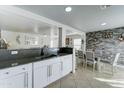 Bright, open kitchen with white cabinets, stainless steel sink, and views into the dining area at 12621 W Aster Dr, El Mirage, AZ 85335