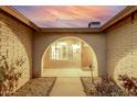 Inviting entryway showcasing an arched opening, brick accents, and a charming front door with unique design at 14013 N 57Th Pl, Scottsdale, AZ 85254