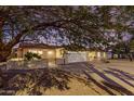 Inviting home featuring a large tree providing shade, well-maintained landscaping, and a two-car garage at 14013 N 57Th Pl, Scottsdale, AZ 85254