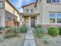 Welcoming entryway with desert landscaping leading to a charming home with a covered porch at 14247 W Bronco Trl, Surprise, AZ 85387