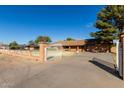 A beautiful home with a gated entrance and long driveway, nestled among mature trees in a well maintained yard at 14251 N 182Nd Ave, Surprise, AZ 85388