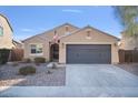 Charming single-story home featuring neutral stucco, a two-car garage, desert landscaping, and an American flag at 2009 E Lindrick Dr, Gilbert, AZ 85298