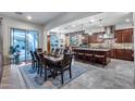 Open-concept kitchen and dining area with a large island, stone accents, and modern appliances at 20125 E Via Del Rancho --, Queen Creek, AZ 85142