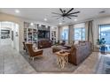Spacious living room featuring built-in bookshelves, a large TV, and comfortable leather seating at 20125 E Via Del Rancho --, Queen Creek, AZ 85142