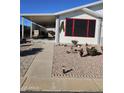 This home showcases a nicely landscaped yard with a quaint walkway leading to a covered carport area at 2400 E Baseline Ave # 58, Apache Junction, AZ 85119