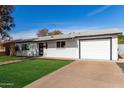 Exterior view of a single story home featuring an attached garage and landscaped front yard at 2418 W Flower St, Phoenix, AZ 85015