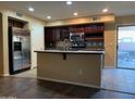 Open kitchen with stainless steel appliances, a center island, dark cabinets, and sliding door to patio at 25532 W Williams W St, Buckeye, AZ 85326