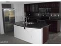 Modern kitchen featuring dark cabinets, stainless steel appliances, granite countertops, and a center island at 25532 W Williams W St, Buckeye, AZ 85326