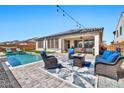 Backyard with a pool, seating area, and covered patio at 25945 W Sands Dr, Buckeye, AZ 85396
