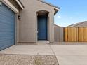 Inviting home entrance featuring a blue front door, a matching garage door and a concrete walkway at 2673 E San Miguel Dr, Casa Grande, AZ 85194