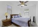 Cozy bedroom with a comfortable bed, ceiling fan, and a window offering natural light at 36602 W San Alvarez Ave, Maricopa, AZ 85138