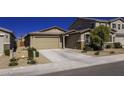 Single-story home featuring a two-car garage, desert landscaping and a nearby utility box at 36602 W San Alvarez Ave, Maricopa, AZ 85138