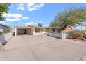 Welcoming single-story home featuring a white fence, mature landscaping, and a covered carport at 416 W Chambers St, Phoenix, AZ 85041