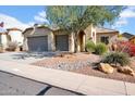 Charming home with a neutral color palette, three-car garage and desert landscaping in a sunny setting at 42823 N Courage Trl, Anthem, AZ 85086