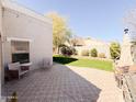 Inviting backyard with a decorative patio, green lawn, mature trees, and cozy seating area at 440 E March St, San Tan Valley, AZ 85140
