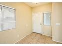 Inviting entryway featuring tile flooring, a white front door, and abundant natural light from multiple windows at 45049 W Cypress Ln, Maricopa, AZ 85139