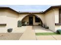 Inviting front porch with a small outdoor dining set and unique arched entrance at 7334 W Sunnyside Dr, Peoria, AZ 85345