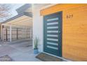 Modern front door with glass inserts, complemented by wood accents and a covered carport at 829 W Mitchell Dr, Phoenix, AZ 85013