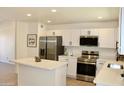 Bright kitchen features white cabinetry, stainless steel appliances, and a functional center island at 9019 W Griswold Rd, Peoria, AZ 85345