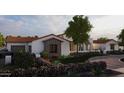 Charming stucco house showcases detailed wooden window features, complemented by colorful landscaping at Xxx N 158Th Ave, Surprise, AZ 85387