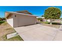 Beige home featuring a two-car garage and wide driveway at 10439 W Saratoga Cir, Sun City, AZ 85351