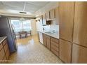 Traditional kitchen with wood cabinets, stainless steel appliances, and a dining area with abundant natural light at 10450 W Sutters Gold Ln, Sun City, AZ 85351