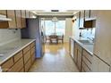 Traditional kitchen with wood cabinets, stainless steel appliances, and a dining area with abundant natural light at 10450 W Sutters Gold Ln, Sun City, AZ 85351