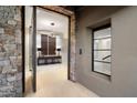 Inviting foyer featuring stone accents, modern lighting, and a glimpse into the home at 10585 E Crescent Moon Dr # 44, Scottsdale, AZ 85262