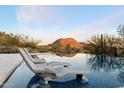 Relaxing lounge chairs sitting on the pool's edge, overlooking desert landscape at 10585 E Crescent Moon Dr # 44, Scottsdale, AZ 85262