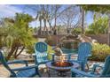 Outdoor seating area with a fire pit, perfect for entertaining, near the pool's rock waterfall feature at 1113 E Devon Dr, Gilbert, AZ 85296