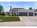 A lovely single-story home features a well-manicured lawn and a three-car garage with a tile roof at 1233 E Azure Sea Ln, Gilbert, AZ 85234