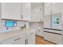 Gourmet kitchen with white cabinets, stainless steel appliances, quartz countertops, and stylish backsplash at 1356 E Penedes Ct, Gilbert, AZ 85298