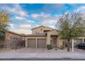 Charming home showcasing a two-car garage, desert landscaping, and a welcoming front patio at 14257 W Harvard St, Goodyear, AZ 85395