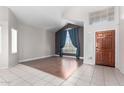 Spacious living room with a high ceiling and big window has tile and wood flooring and natural light throughout at 15618 N 12Th Ave, Phoenix, AZ 85023