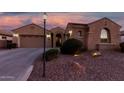 Inviting home featuring a two-car garage, desert landscaping, and an arched entryway at 2089 E Lynx Pl, Chandler, AZ 85249