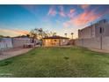 Spacious backyard with well-maintained lawn, covered patio with cafe lights, and ample room for activities at 2209 N 23Rd St, Phoenix, AZ 85006