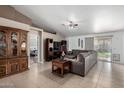 Cozy living room with tile flooring, a ceiling fan, and ample natural light creating a warm ambiance at 2251 E Remington Pl, Chandler, AZ 85286