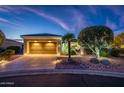 Beautiful single-story home with desert landscaping, illuminated path, and an attached two-car garage at 23318 N Las Positas Ct, Sun City West, AZ 85375