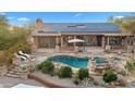 Stunning aerial view of a house showing off the pool, solar panels, patio, and professionally landscaped yard at 27641 N 74Th St, Scottsdale, AZ 85266