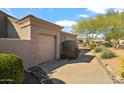 Beige home featuring a two-car garage, desert landscaping, and a walkway at 27913 N Walnut Creek Rd, Rio Verde, AZ 85263