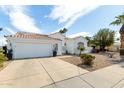 Beautiful single-story home featuring desert landscaping, a tiled roof, and a three car garage at 2909 N 111Th Dr, Avondale, AZ 85392