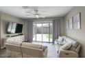 Comfortable living room featuring a large sliding glass door with backyard views at 40789 W Shaver Dr, Maricopa, AZ 85138