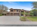 Attractive two-story home with a well-manicured lawn, mature trees, and a three-car garage at 4297 S Marion Pl, Chandler, AZ 85249