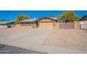 Tan single-story home with desert landscaping and an attached two-car garage at 516 E Mesquite Ave, Apache Junction, AZ 85119