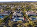 This aerial view showcases a backyard oasis with a sparkling pool, patio with seating, and lush desert landscaping at 5421 E Juniper Canyon Dr, Cave Creek, AZ 85331