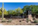 Elegant stone community sign reading 'Bellissima' amidst desert landscape, tall Saguaro cactus and clear blue sky at 5421 E Juniper Canyon Dr, Cave Creek, AZ 85331