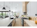 Contemporary kitchen with sleek countertops, stainless steel appliances, and a dining area in the background at 6313 N 10Th Dr, Phoenix, AZ 85013