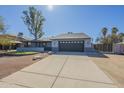 Single-story home with gray exterior, spacious driveway, and desert landscaping at 6841 W Yucca St, Peoria, AZ 85345